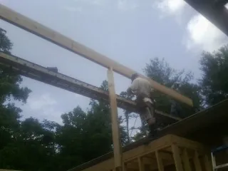 Carpenter setting a ridge beam over a new addition frame — Ice Dam Removal by Roofing Brothers in West Henrietta