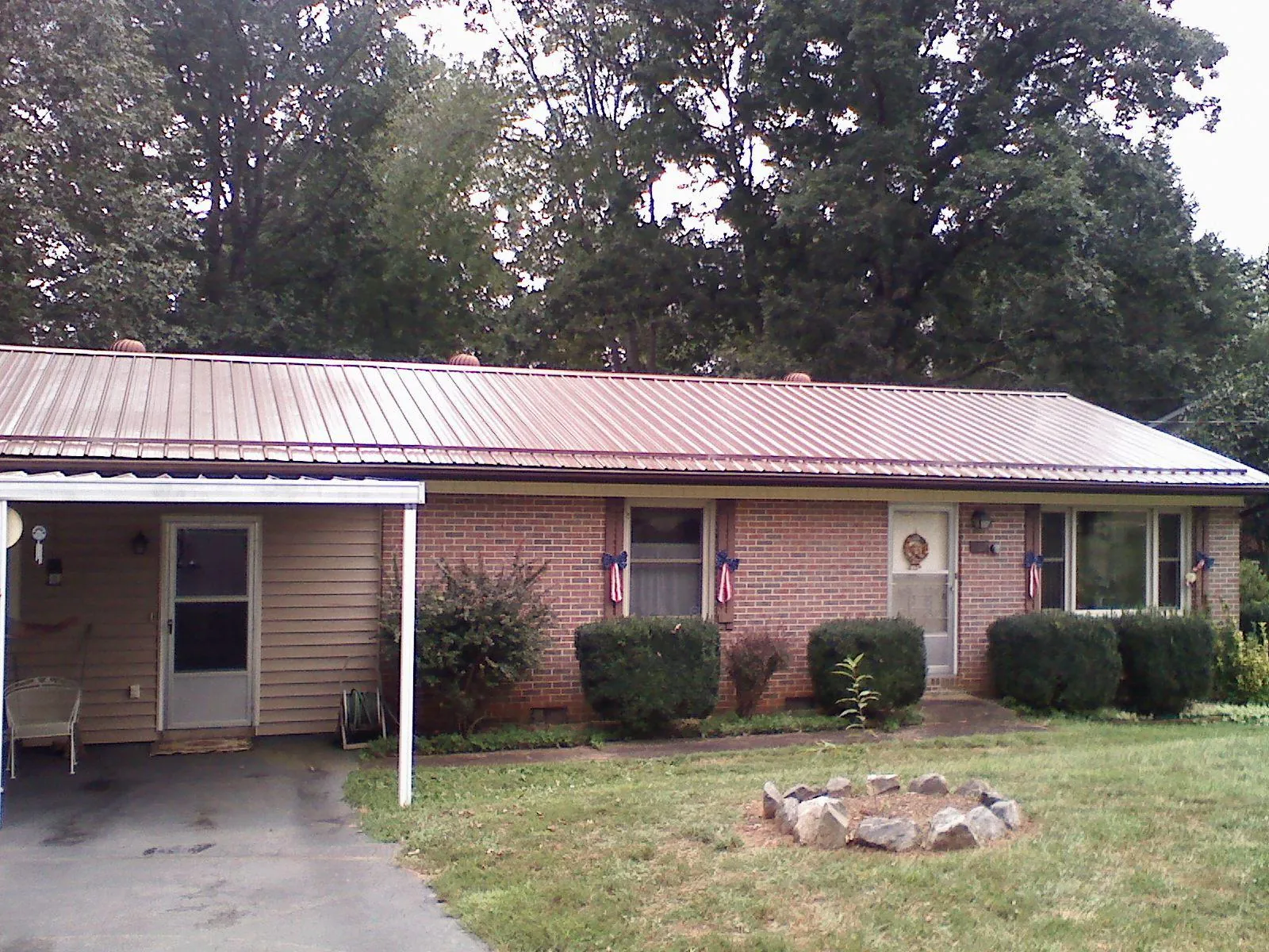 Bronze metal roof and carport on a brick ranch home — Roof Repair work by our crew in West Henrietta